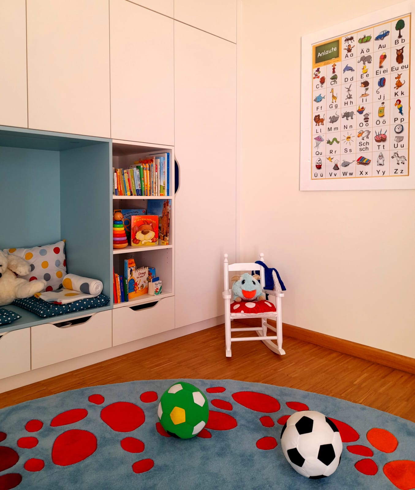 Bunt gestaltetes Kinderzimmer mit Bücherregal, Sitzbereich und Spielzeug.